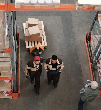 pexels-photo-4481260-4481260 High angle view of warehouse workers organizing and preparing shipments with boxes and pallets.